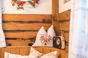 a room with a bed with pillows and a radio at Hochfügenblick-ski- und Wanderhütte in Hochfugen