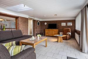 a living room with a couch and a tv at Ferienwohnung Schmolei in Kronprinzenkoog