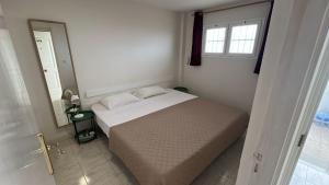 a small bedroom with a bed and a window at Mirador los molinos in San Bartolomé