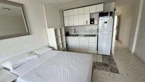 a white kitchen with a bed and a refrigerator at Mirador los molinos in San Bartolomé