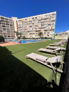 a group of lounge chairs on a lawn in front of a building at Mirador los molinos in San Bartolomé