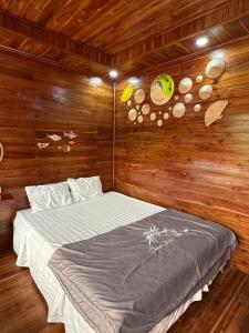 a bedroom with a bed with wooden walls and wooden floors at Cô Tô Homestay 368 in Chung Cap