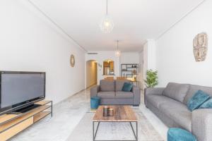 a living room with two couches and a flat screen tv at Calpe Bay in Calpe