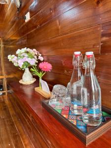 a table with three bottles and glasses on it at Cô Tô Homestay 368 in Chung Cap
