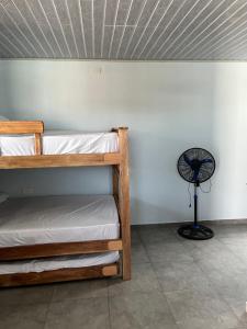 a room with two bunk beds and a fan at El Castillo in Moñitos