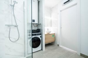 a bathroom with a shower and a washing machine at Ptm riverview T2 luxe 2nd floor in Portimão