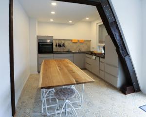 a kitchen with a wooden table and two stools at Quartierblancdenoir Wohnungen in Reil +23 photos