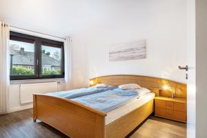a bedroom with a bed and a window at Ferienwohnung Schmolei in Kronprinzenkoog