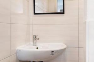 a white sink in a white bathroom with a mirror at Lilly in Meßkirch +8 photos