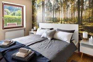 a bedroom with a large bed with a forest mural at Am Sommerrain in Elzach