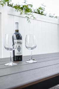 a bottle of wine and two wine glasses on a table at 2bd Suite Steps To Beach! - Private Patio & Grill! in Oceanside