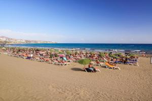 a beach with a lot of people sitting on chairs and umbrellas at Un descanso 1 in San Fernando