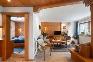 a bedroom with a bed and a living room at Ferienhaus Werdenfels in Mittenwald
