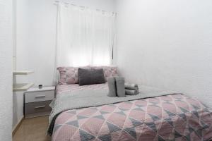 a bedroom with a pink bed and a white wall at Un descanso 1 in San Fernando