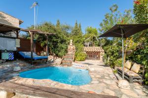 a swimming pool in a yard with an umbrella at La Cuina De Paqui in Caserío Calandari