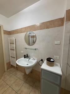 a bathroom with a sink and a mirror at La Masera sul Torrente By Immobilux in Mori +2 photos