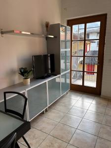 a living room with a tv and a sliding glass door at La Masera sul Torrente By Immobilux in Mori