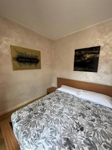 a bedroom with a bed and two paintings on the wall at La Masera sul Torrente By Immobilux in Mori
