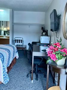 a hotel room with a desk and a bed at Motel West in Bend