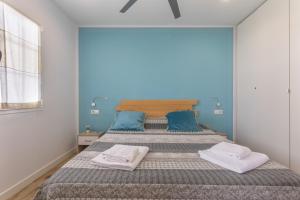 a bedroom with a large bed with blue walls at Melissa Apartment in Alaior +23 photos