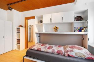 a bedroom with a bed with white cabinets and a shelf at Ferienwohnung Eva Maria in Pforzheim