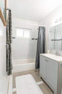 a bathroom with a white tub and a sink at 2bd Suite Steps To Beach! - Private Patio & Grill! in Oceanside +26 photos