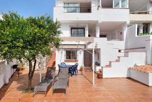 a patio with benches and tables in front of a building at Casa Torremuelle in Benalmádena