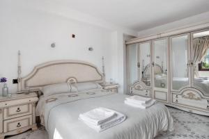 a white bedroom with a bed and a mirror at Casa Torremuelle in Benalmádena +34 photos