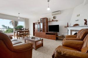 a living room with two couches and a tv at Casa Torremuelle in Benalmádena