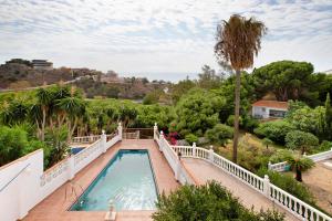 a swimming pool on a balcony with a view of trees at Casa Torremuelle in Benalmádena