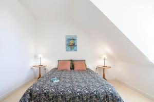 a bedroom with a bed with two lamps at La Pause Bigoudène in Penmarch