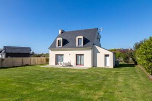 a white house with a gray roof on a yard at La Pause Bigoudène in Penmarch