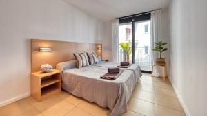 a bedroom with a large bed and a large window at Costacabana - Apartment Dali in Lloret de Mar