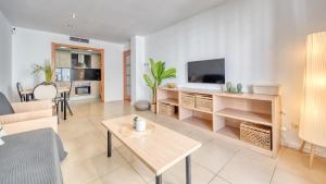 a living room with a table and a tv at Costacabana - Apartment Dali in Lloret de Mar