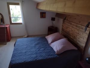 a bedroom with a bed with a wooden headboard at L'arbre Du Magnan - Gîte En Ardèche in Chandolas +10 photos