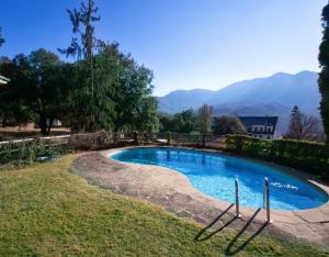 a swimming pool in a yard with mountains in the background at Petit Castanyer in Viladrau