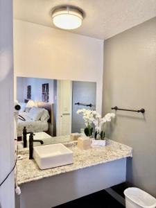 a bathroom with a counter with a sink and a mirror at Motel West in Bend