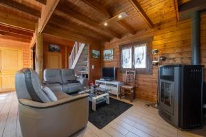 a living room with a couch and a television in a log cabin at Chalet de Monique in Le Val-dʼAjol