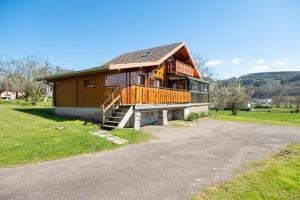 a large wooden house with a porch and a driveway at Chalet de Monique in Le Val-dʼAjol