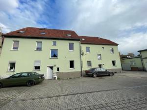 two cars parked in front of a large building at Das grüne Haus in Finsterwalde