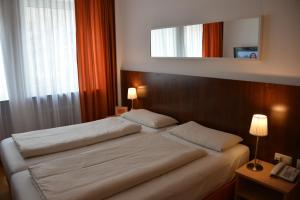 a hotel room with a bed and two lamps at Hotel Italia in Munich
