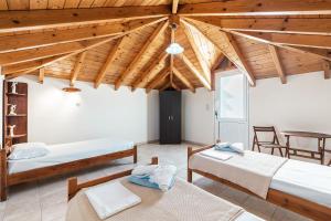 a room with three beds and a wooden ceiling at Blue Pearl in Lachania