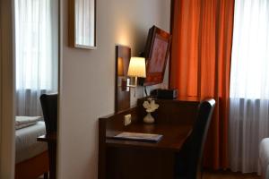 a bed room with a lamp and a desk at Hotel Italia in Munich