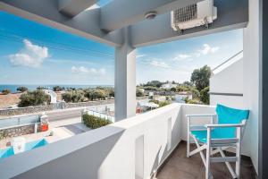 a balcony with a blue chair and a view of the ocean at Blue Pearl in Lachania