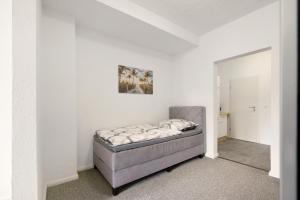 a bedroom with a bed in a white room at Lisbeth in Sankt Wendel