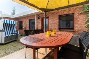 a wooden table with two cups on a patio at Haus Laffina in Büsum