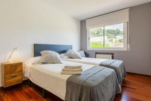 a bedroom with two beds and a window at Casa con jardín próxima a Barcelona in Sant Andreu de Llavaneres