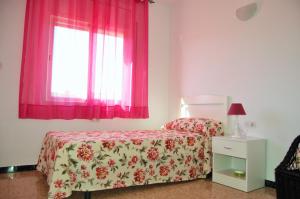 リョレート・デ・マルにあるVilla Dorisのベッドルーム1室(ベッド1台付)、ピンクのカーテン付きの窓が備わります。 +35枚の写真