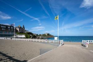a beach with a white fence and a yellow flag at Joisalig in Saint-Quay-Portrieux +15 photos