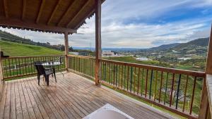 a wooden balcony with a table and a view at Ecoparque Hotel El Cielo Cabañas in Carmen de Viboral